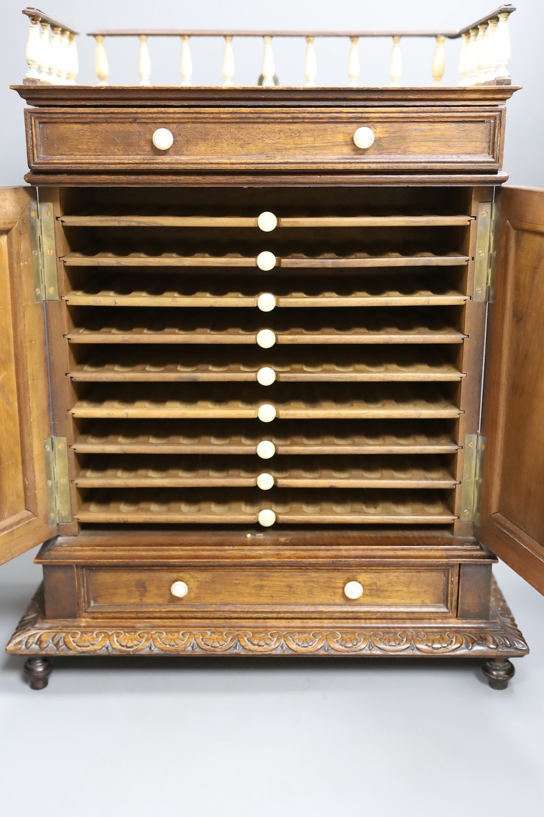 A 19th century walnut cigar cabinet, with an ivory and bone gallery., 6 cms wide x 45 cms high.